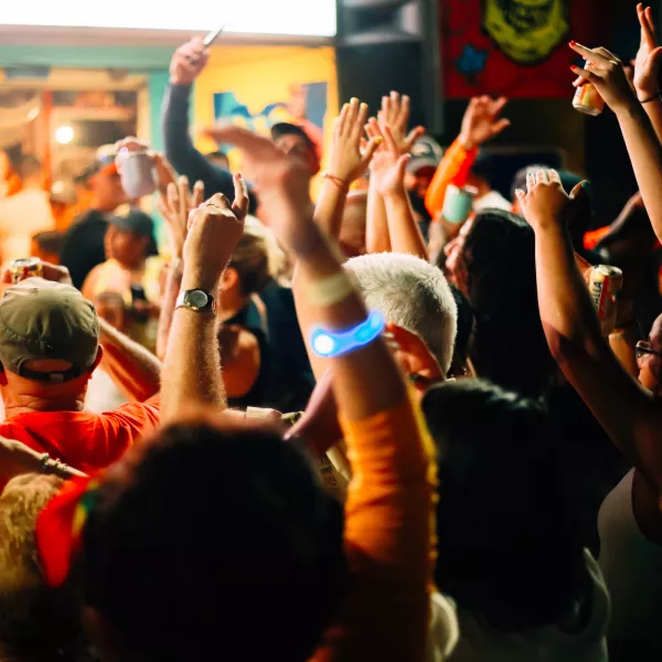 Crowd gathered at night in La Placita de Santurce, with people raising their hands and enjoying live music, nightlife, and the lively atmosphere of one of San Juan's most popular social destinations.