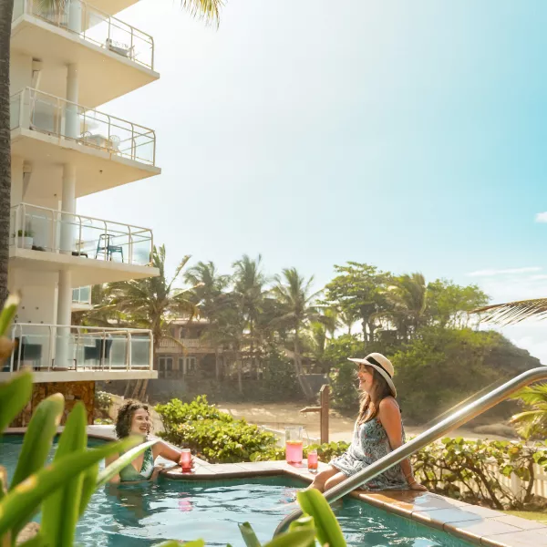 Two guests relax by the pool at a beachfront short-term rental on Puerto Rico’s west coast.