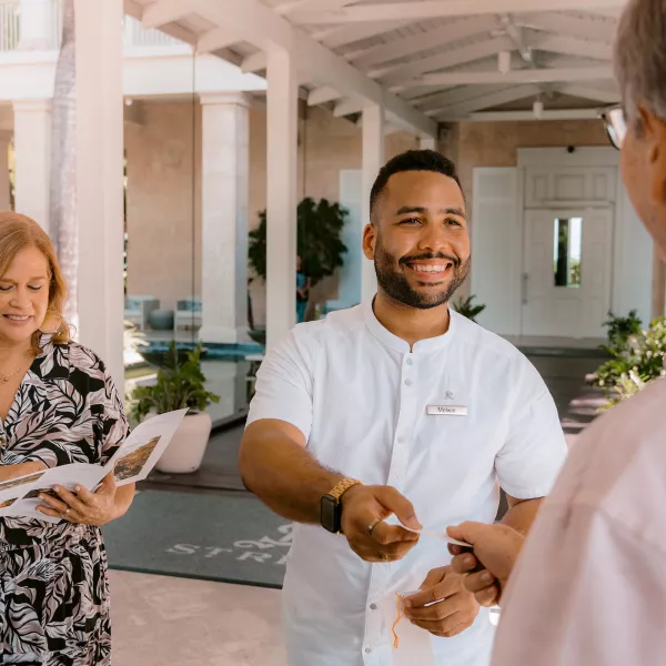A resort staff member welcomes arriving guests at Four Seasons Resort and Residences Puerto Rico, highlighting the personalized service and luxury hospitality that define this beachfront resort.