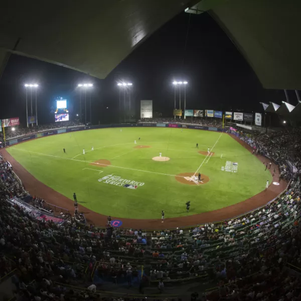 Night view of Hiram Bithorn Stadium in San Juan filled with fans during a baseball game.