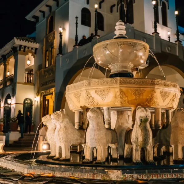 Exterior of the historic Casa de España, featuring an ornate fountain lined with lion sculptures.