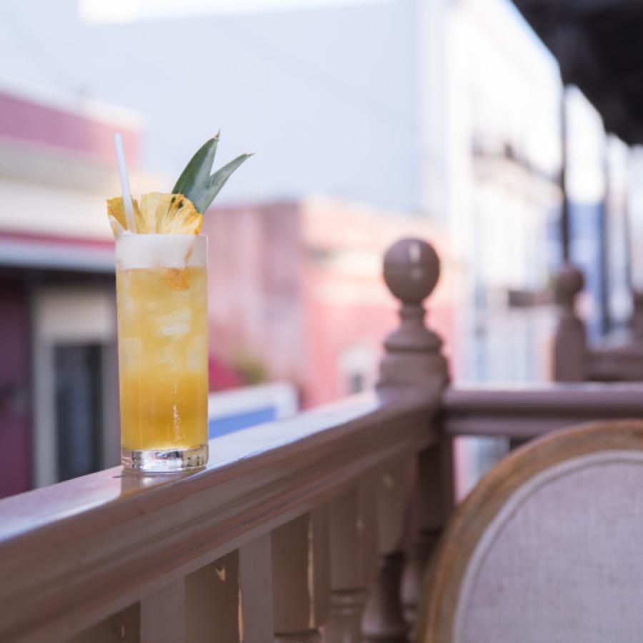 A craft cocktail sits on a balcony railing at The Mezzanine in Old San Juan.
