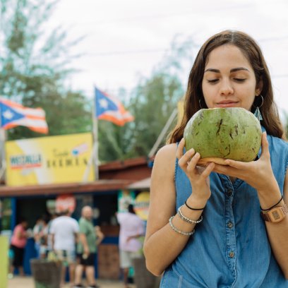 Woman sipping fresh coconut water in Piñones, Puerto Rico
