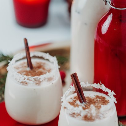 Los vasos de coquito están decorados con ramas de canela.