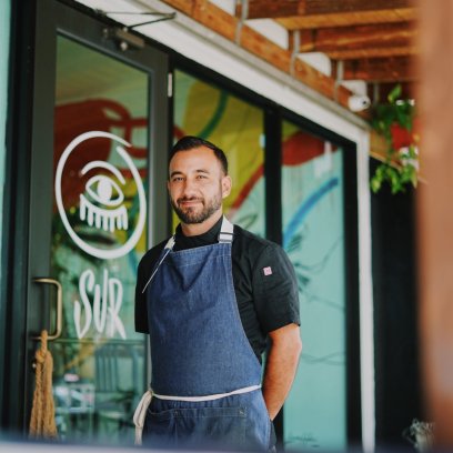 Chef Rafael Ubior posesin front of his restaurant SUR Barra Nikkei