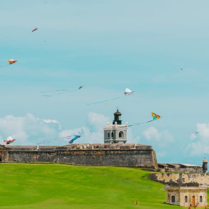 Colorful kites flying over the lawn in front of El Morro, the historic fortress overlooking the Atlantic Ocean in Old San Juan, Puerto Rico.
