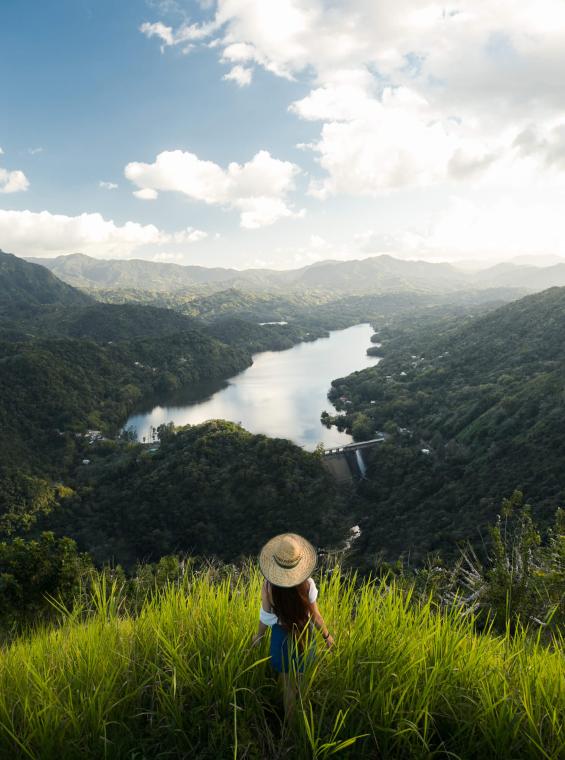 Woman on a hill overlooking Puerto Rican landscape. 