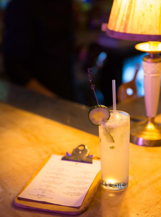 a cocktail and menu on the bar at gallo negro