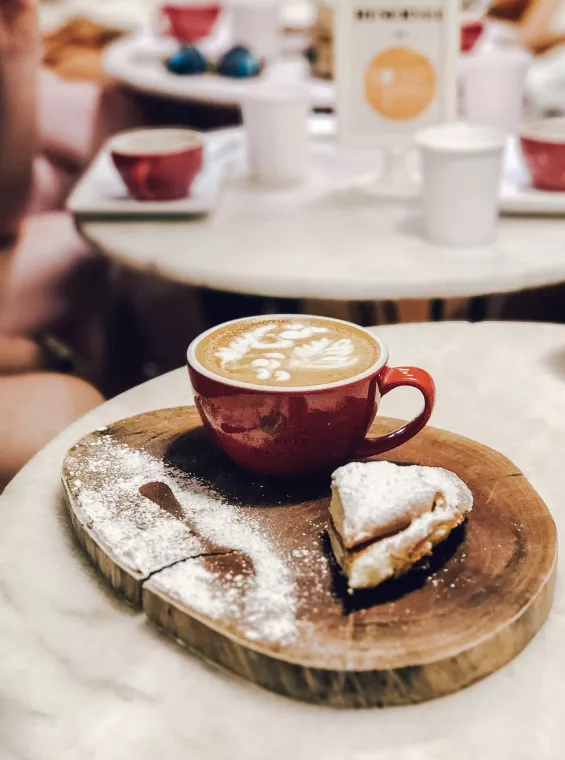 Traditional Puerto Rican mallorca pastry dusted with powdered sugar, served with a cup of local coffee.