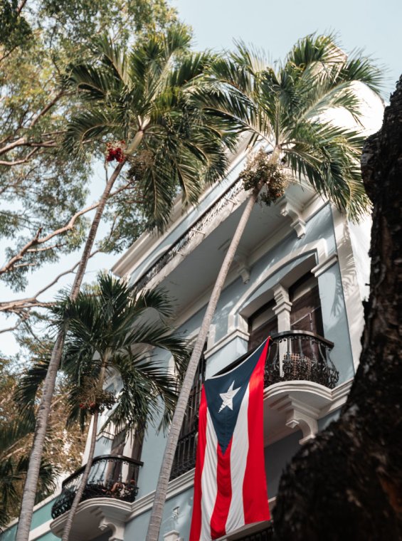 A historic building in Old San Juan with a Puerto Rican flag draped from the balcony.